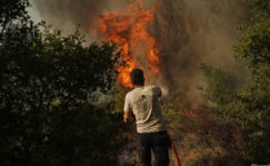 Un hombre trata de apagar un incendio con una manguera
