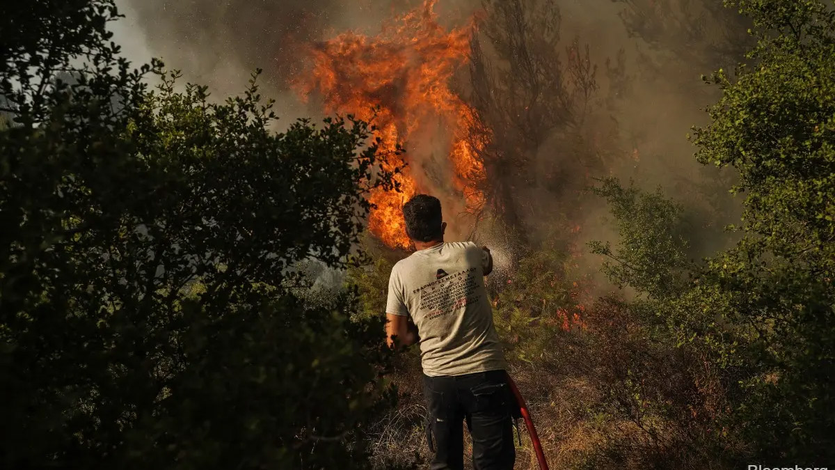 Un hombre trata de apagar un incendio con una manguera
